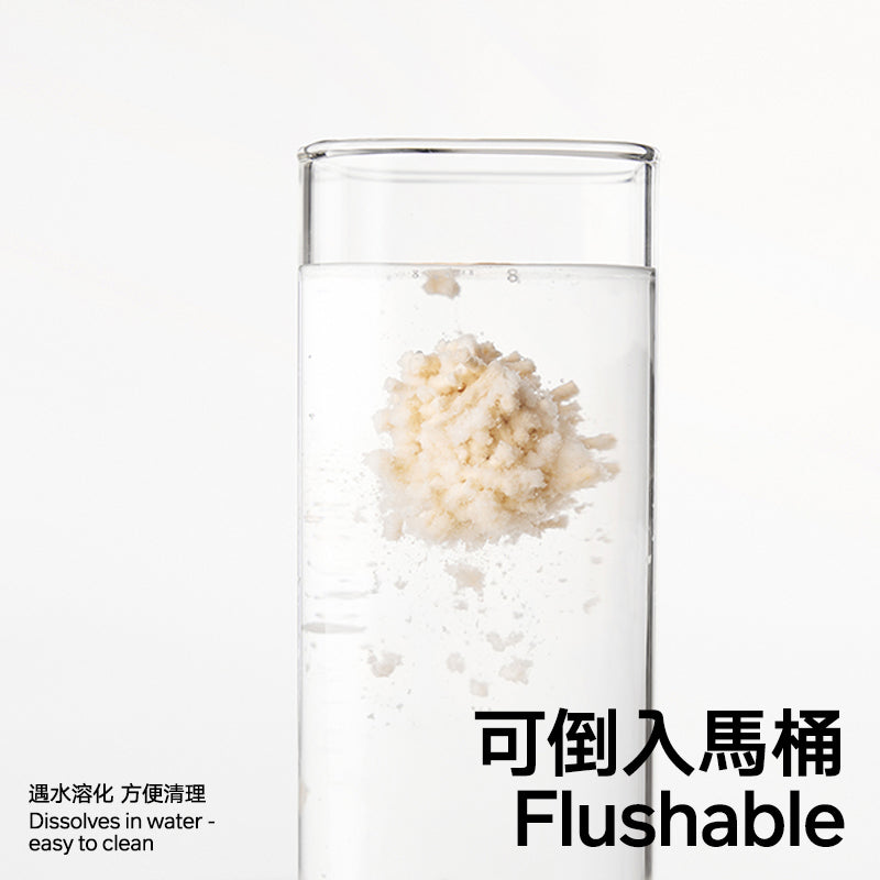 Glass with a cat litter dissolving in water, highlighting cat litter is 'Flushable'.